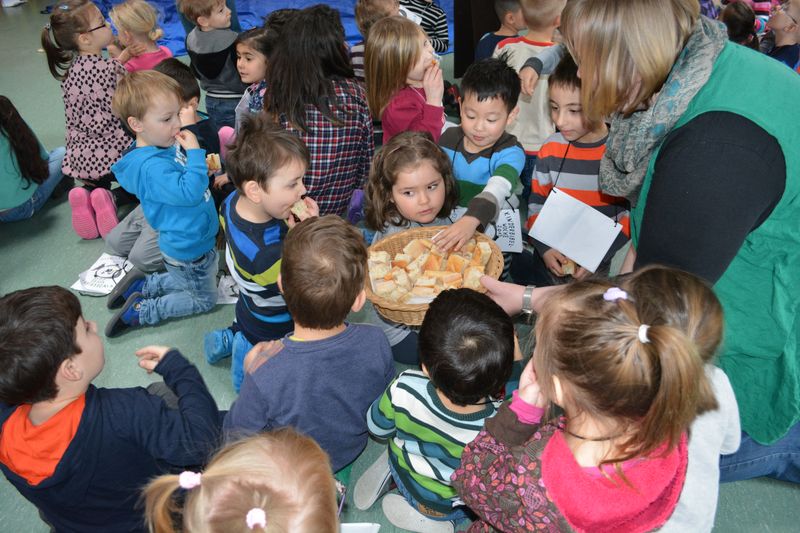 Kinder der Kita Ellhornstraße teilen passend zum vorgespielten biblischen Theaterstück das Brot. 