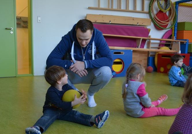 Nachwuchstrainer Simon Macherski im Gespräch mit einem Kita-Kind